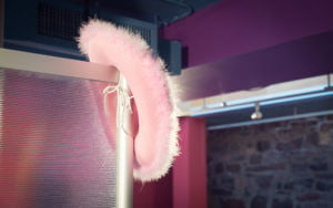 Pink, fuzzy cow girl hat hanging off office wall