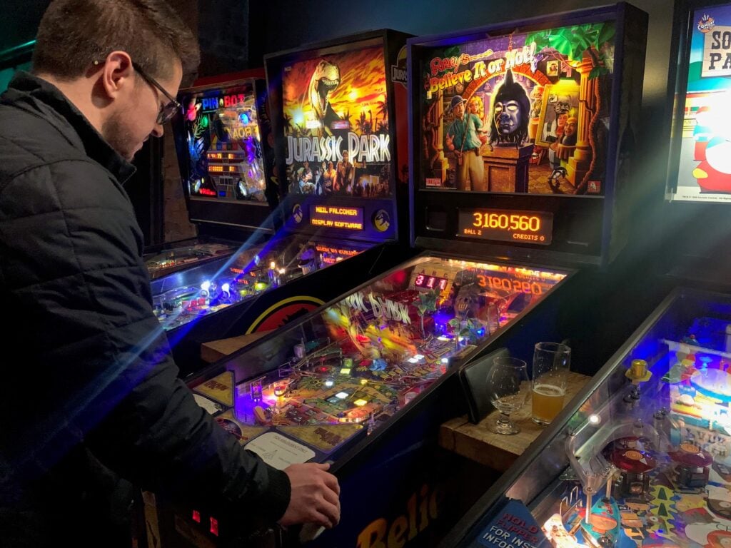 Chris playing pinball at an arcade