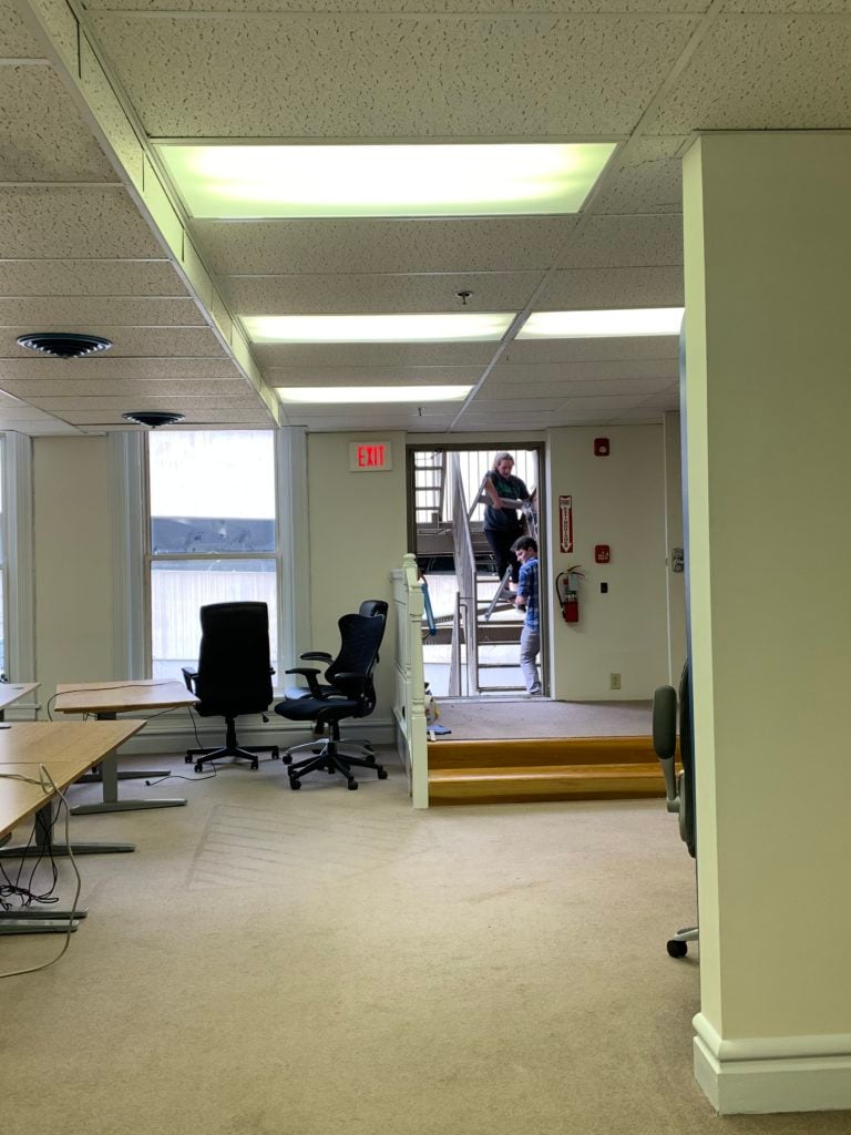 Bytes employees moving desks into second floor dev room