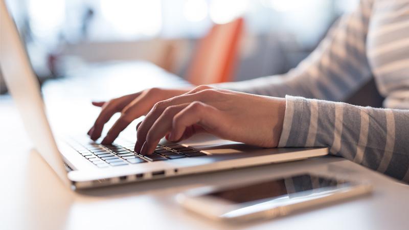 sideview of person typing on laptop