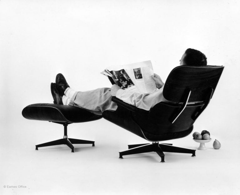 Eames office chair with someone reading a newspaper in it