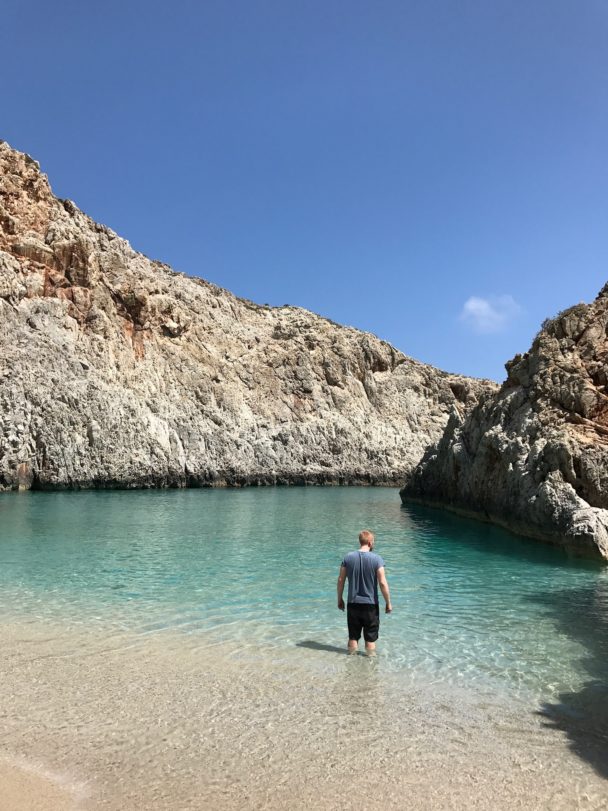 Josh Kirkpatrick standing in the ocean surrounded by rocks