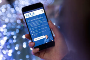 New homepage on the United Counseling Service website on a mobile phone