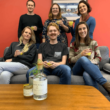 Chris, Hannah, Kristina, Dorian, Scott, Abby sitting on a couch with Bar Hill gin in the foreground