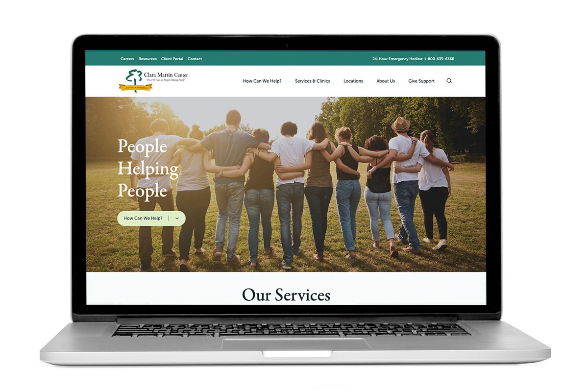 Laptop open and showing the homepage of the Clara Martin Center website, a mental health care provider in Vermont.