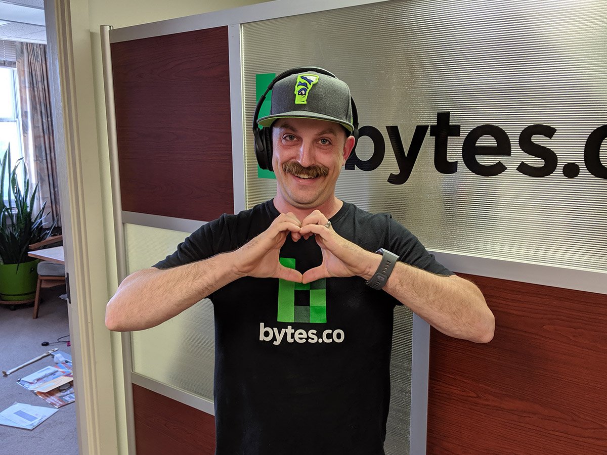Peter Jewett, Bytes founder, makes a heart shape out of his hands while smiling for the camera