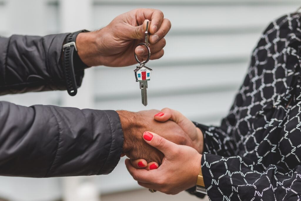 Real estate agent handing over keys and shaking hands