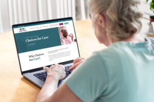 An older woman looking at Age Well's Choices for Care page on a laptop