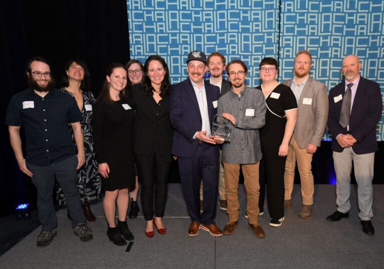 The Bytes.co team standing together on stage to accept the Lake Champlain Chamber 2024 Business of the Year award. From left to right: Aaron Silber, Kristina Drobny, Sarah Maines, Lilly Romano, Catherine Davis (LCC), Peter Jewett, Scott Kliczewski, Hannah Hook, Josh Kirkpatrick