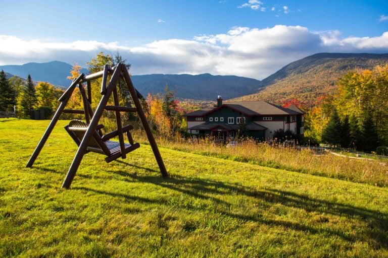 View of a chair swing with Smugglers' Notch Resort and the mountains during the fall