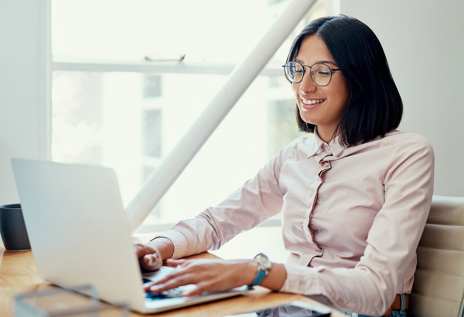 A woman researching website navigation best practices on a laptop at an office